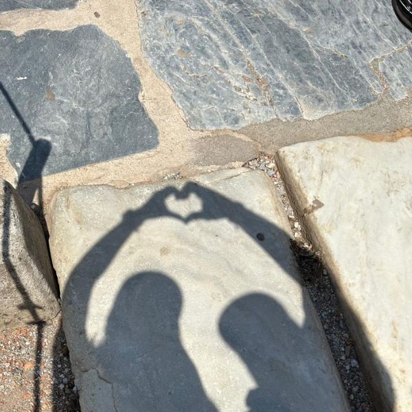 Picture of the shadow of Dog and Dragon making a heart reflect on the concrete.