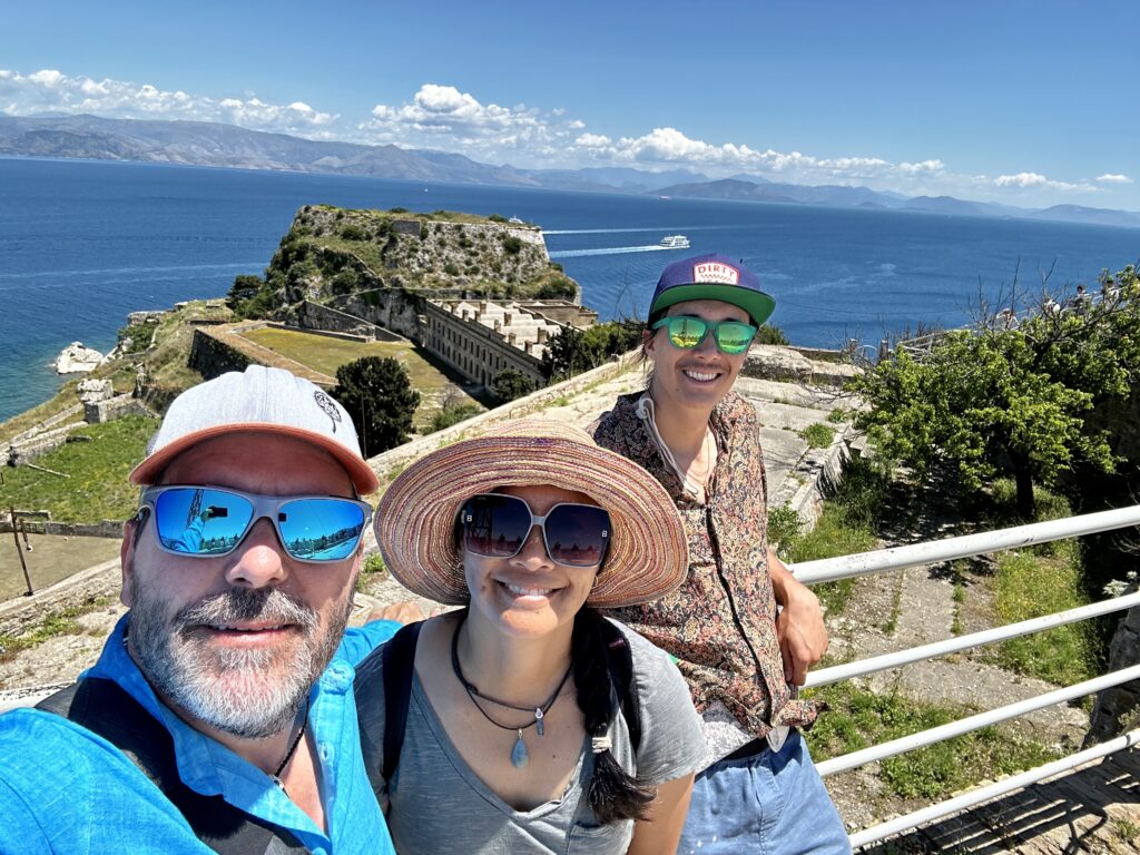 Selfie of Dog, Dragon, and their adult son, Mini-Dragon on top of one of the Venetian fortresses with the sea in the background.