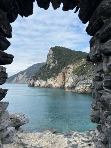 View of the sea and cliffs behind Porto Venere taken through the ancient open window outside the Church of San Pietro